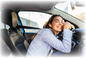 girl hugging her steering wheel in her new car