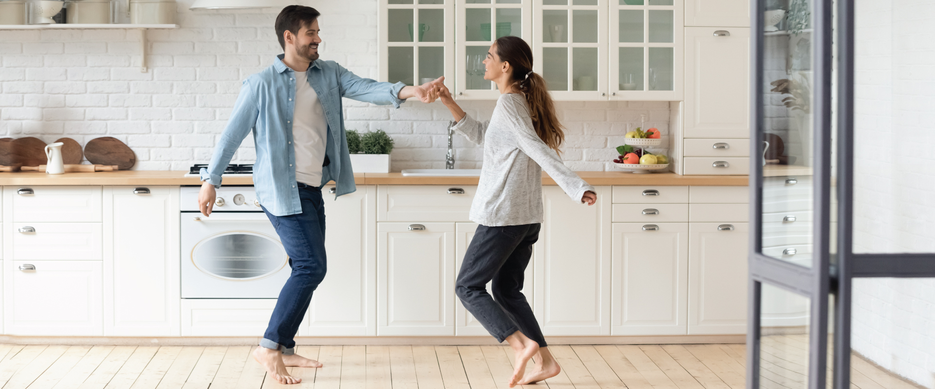 man and woman dancing in their kitchen in their new house